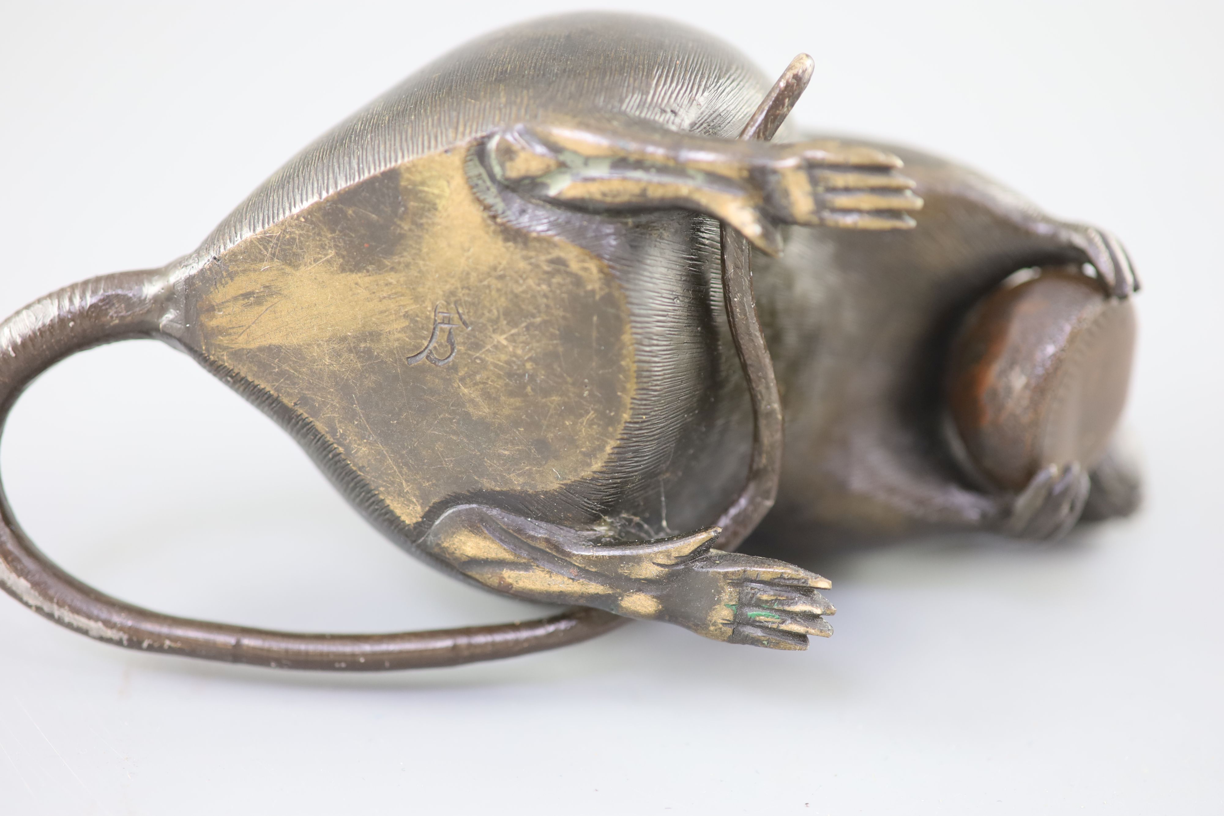 A Japanese bronze model of a rat holding a chestnut, Meiji period, 17cm long